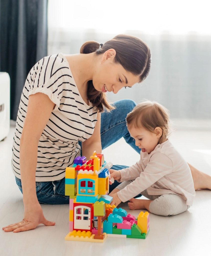 Frau baut mit Kind einen Turm